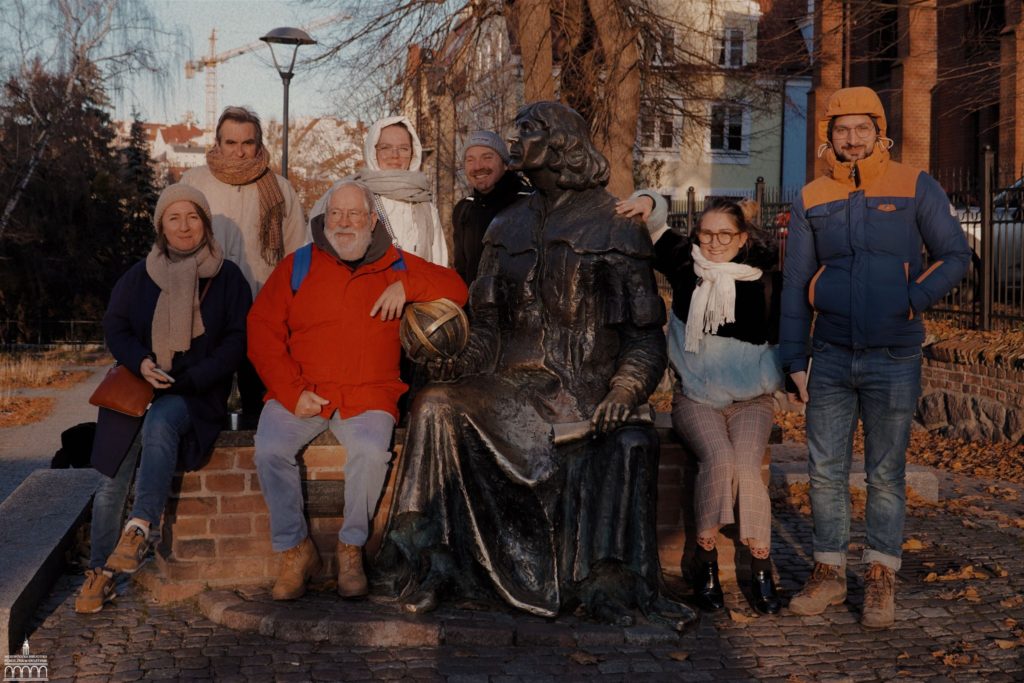 grupa ludzi obok pomnika Mikołaja Kopernika 