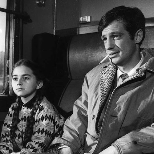 fotos z filmu małpa w zimie. czarnobiałe zdjęcie. Mężczyzna i dziewczynka siedzą w przedziale pociągu.